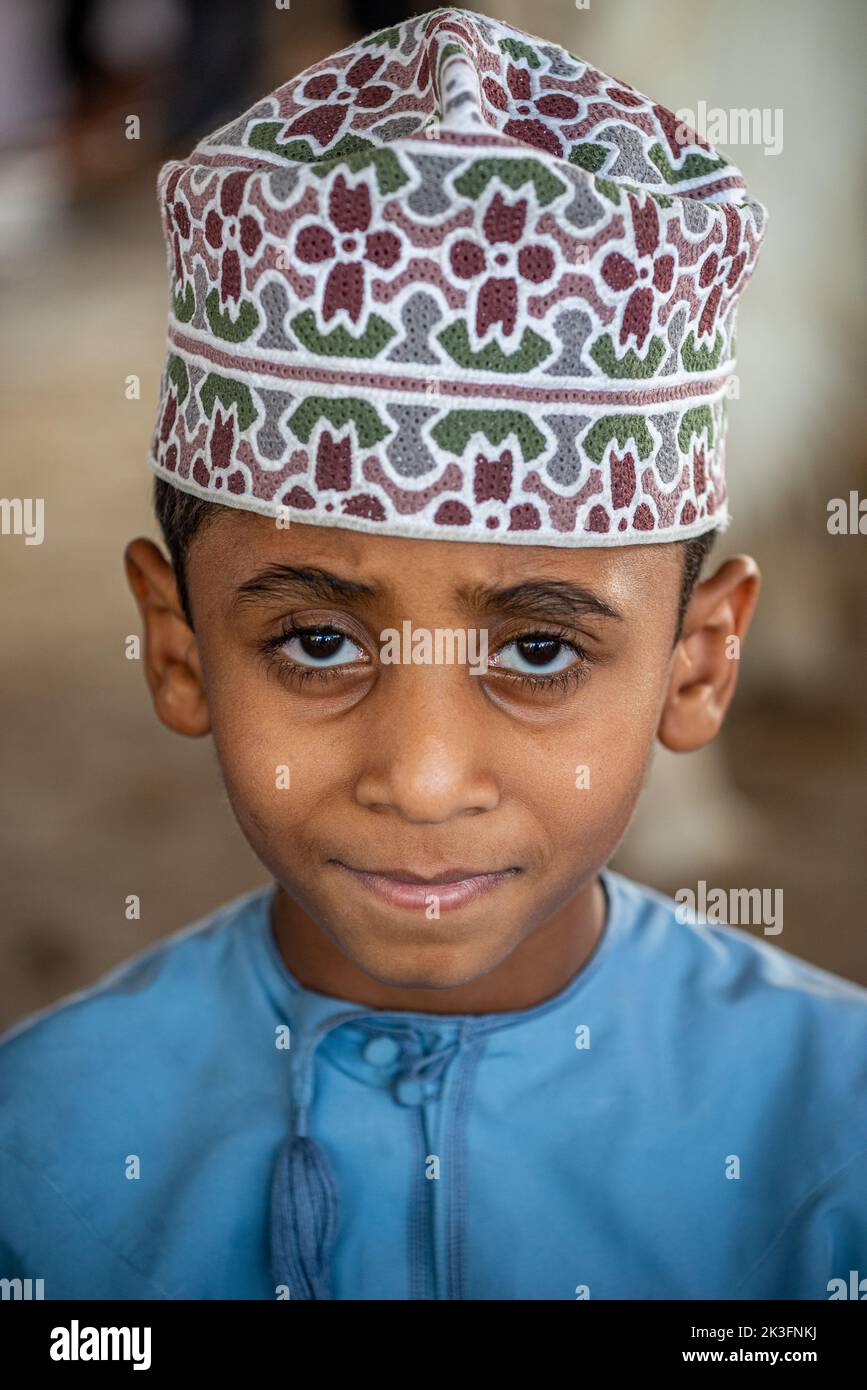 Portrait of a young boy with kuma (omani traditional round hat) at friday morning cattle market, Nizwa, Oman Stock Photo