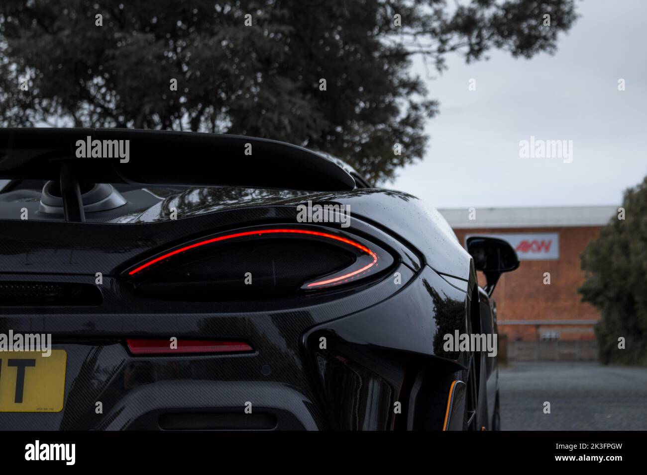 The Rear Quarter Of A 2019 Cosmos Black McLaren 600LT With Carbon Fibre Rear Bumper With LED McLaren Tail light. Stock Photo