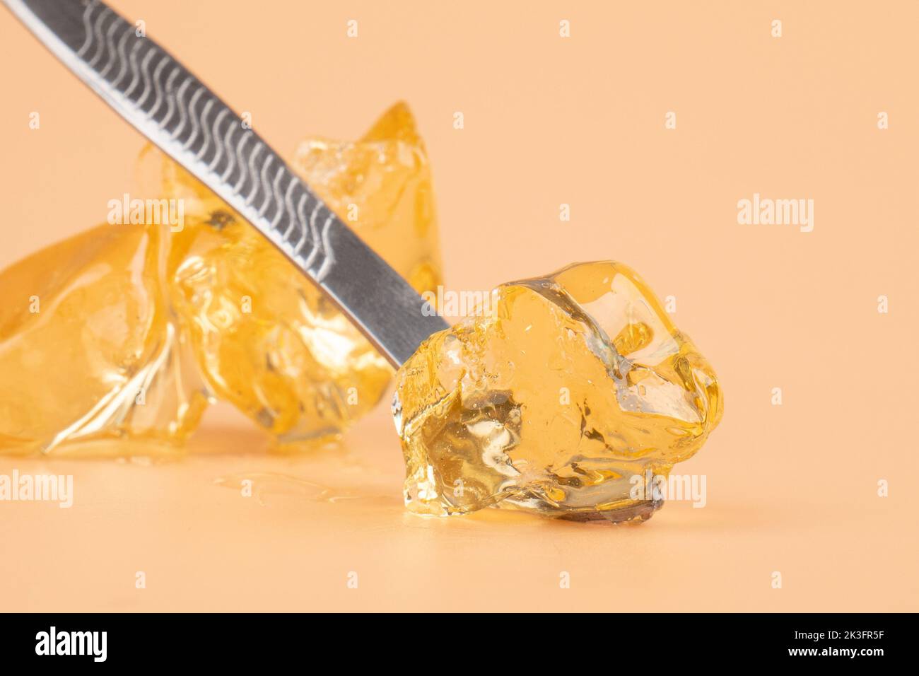 yellow wax with dabbing stick of cannabis resin for smoking high in THC. Stock Photo