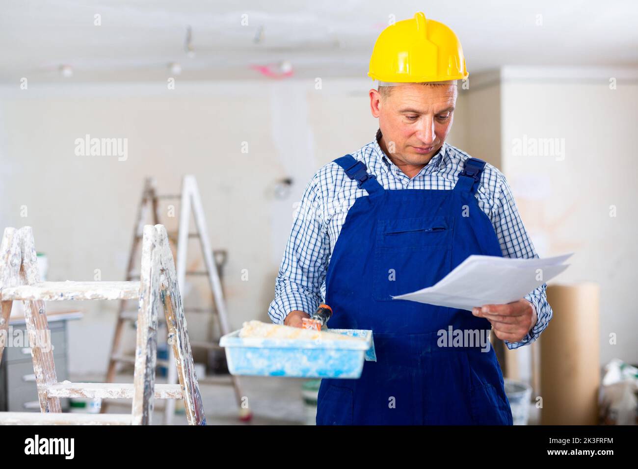 Portrait of painter with documentation in apartment, renovation works