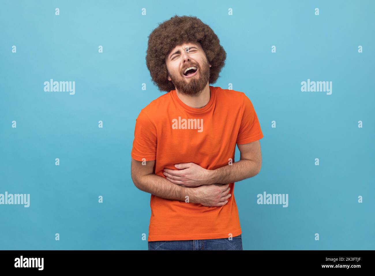 Stomach pain. Portrait of sick sad unhealthy man with Afro hairstyle