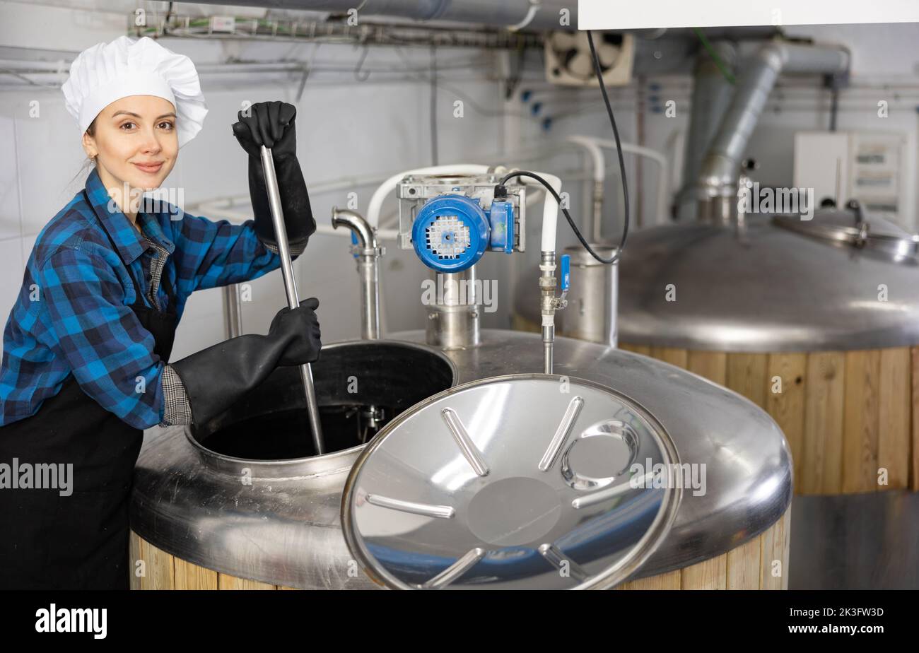 Woman brewmaster mixing beer in tank Stock Photo Alamy