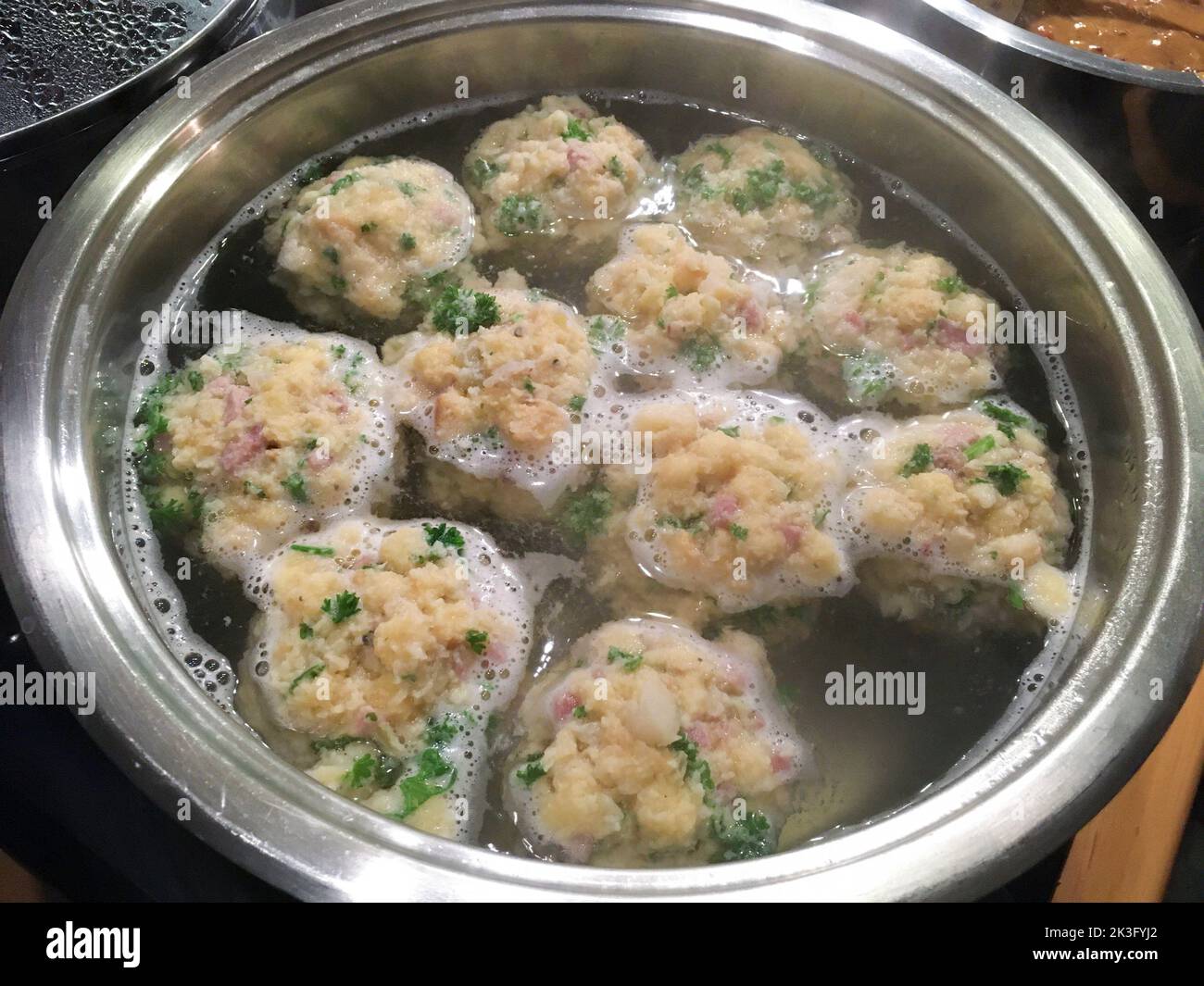 Bayerische Semmelknödel mit Speck, ziehen im Topf Stock Photo