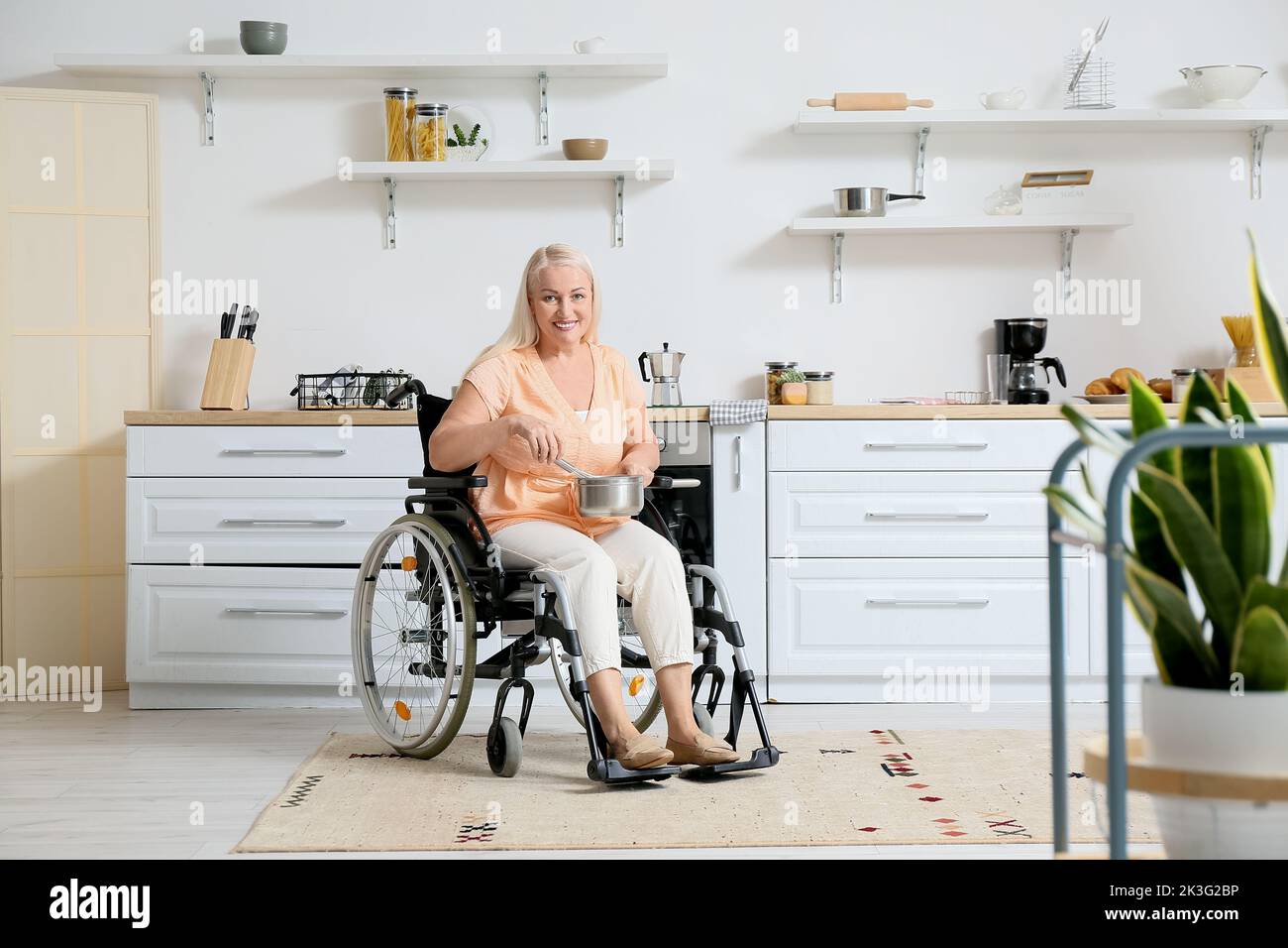 Disabled Cook Mature woman with physical disability cooking in kitchen Stock Photo ...