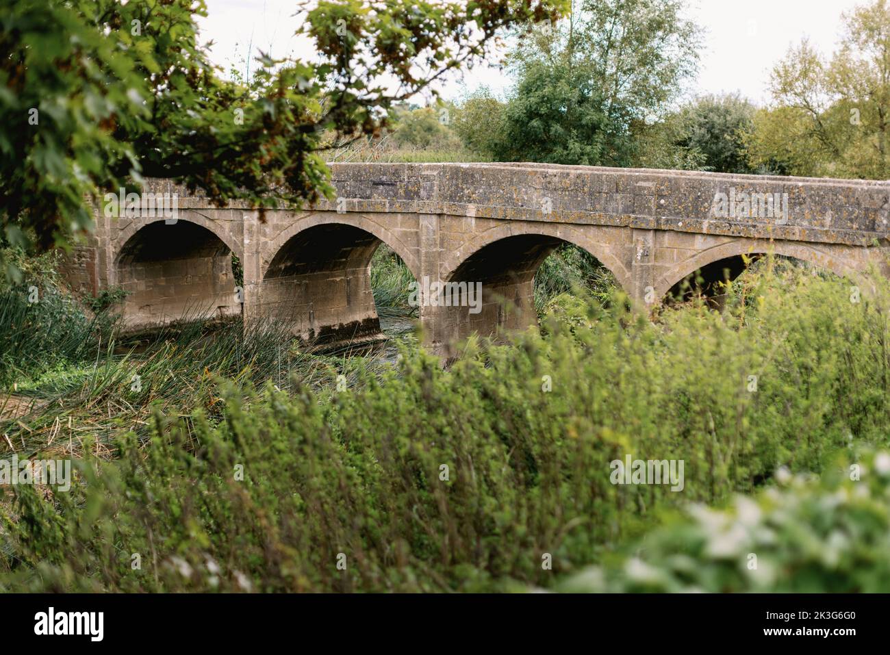 The old arched stone bridge crossing the River Avon in Reybridge (Rey Bridge) near Lacock, Wiltshire, England Stock Photo