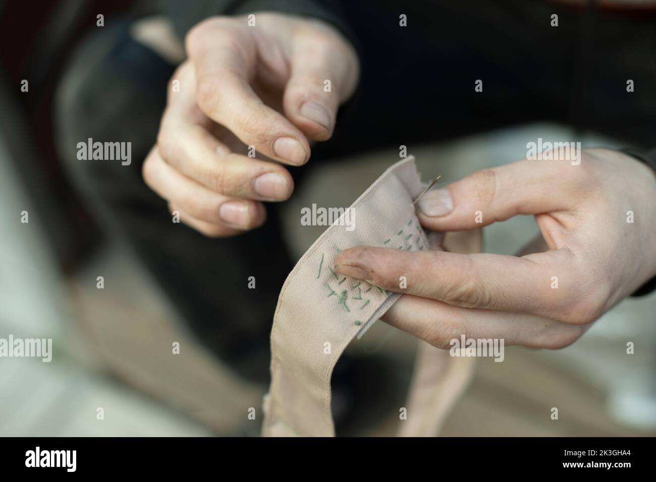 Sewing tape. Collar stitching in army. Work of weaver. Repair clothes with your own hands. Stock Photo