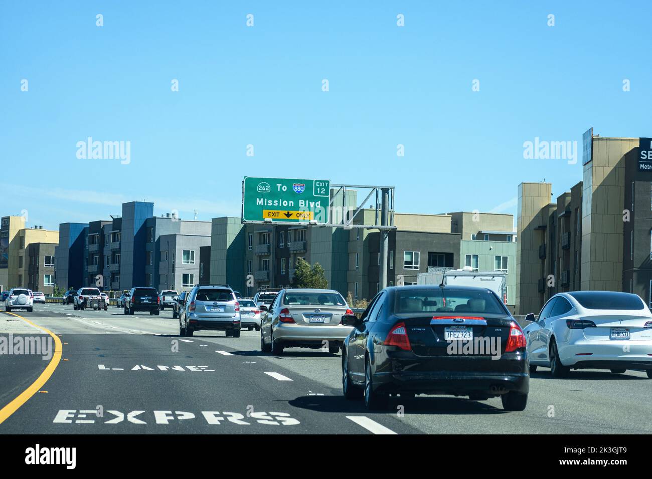 Light vehicle traffic on southbound highway 680 at Mission Boulevard. Express Lane. New modern mid-rise multi-family residential builings along the ro Stock Photo