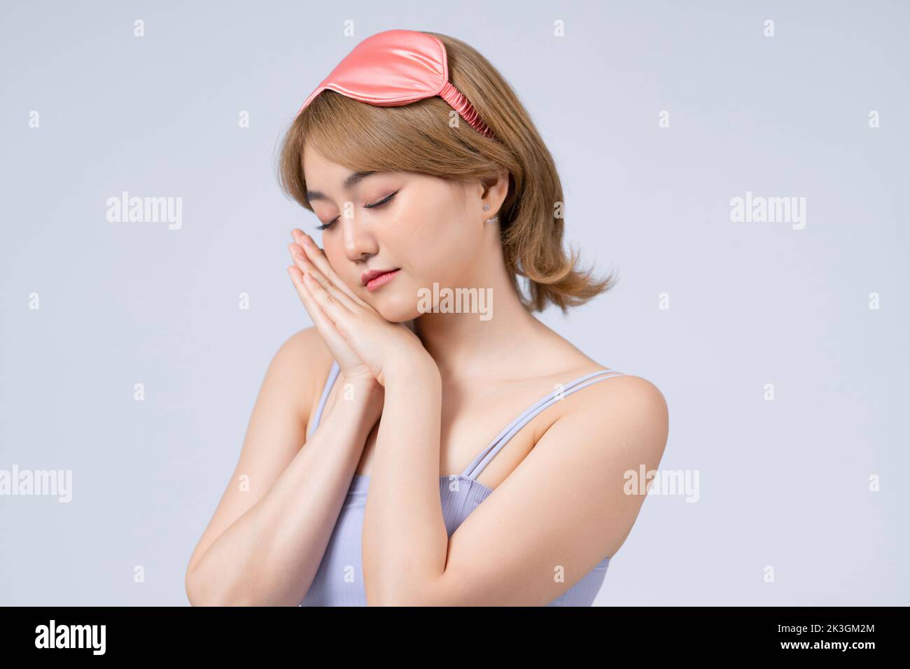 Tired woman wearing sleeping mask isolated on gray background relax fall asleep on hands Stock Photo