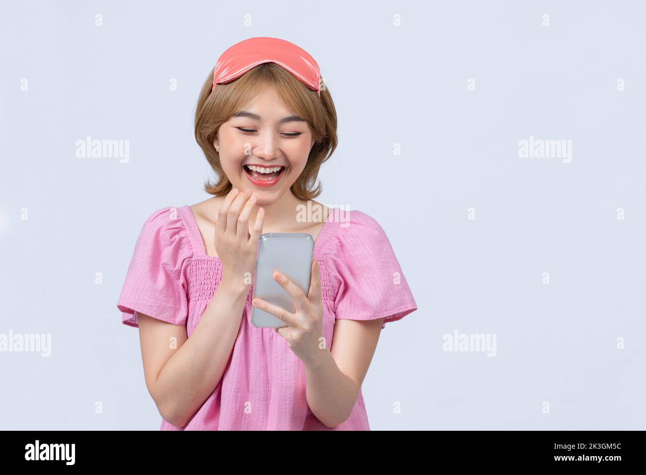 Smiling young girl looking at smartphone screen in the morning Stock Photo