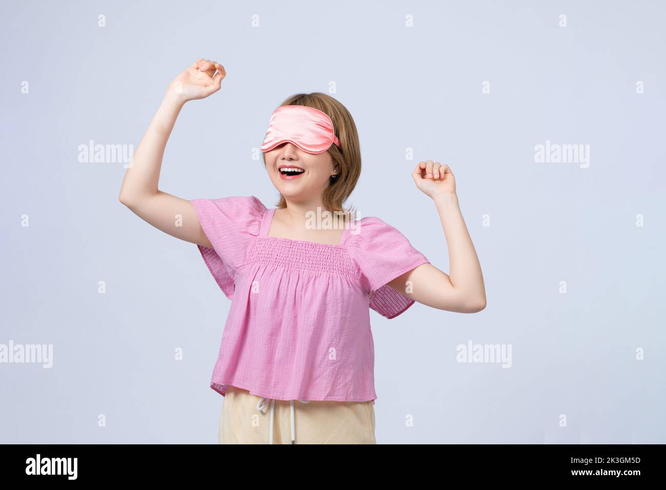 Young woman with sleep mask isolated on white background Stock Photo
