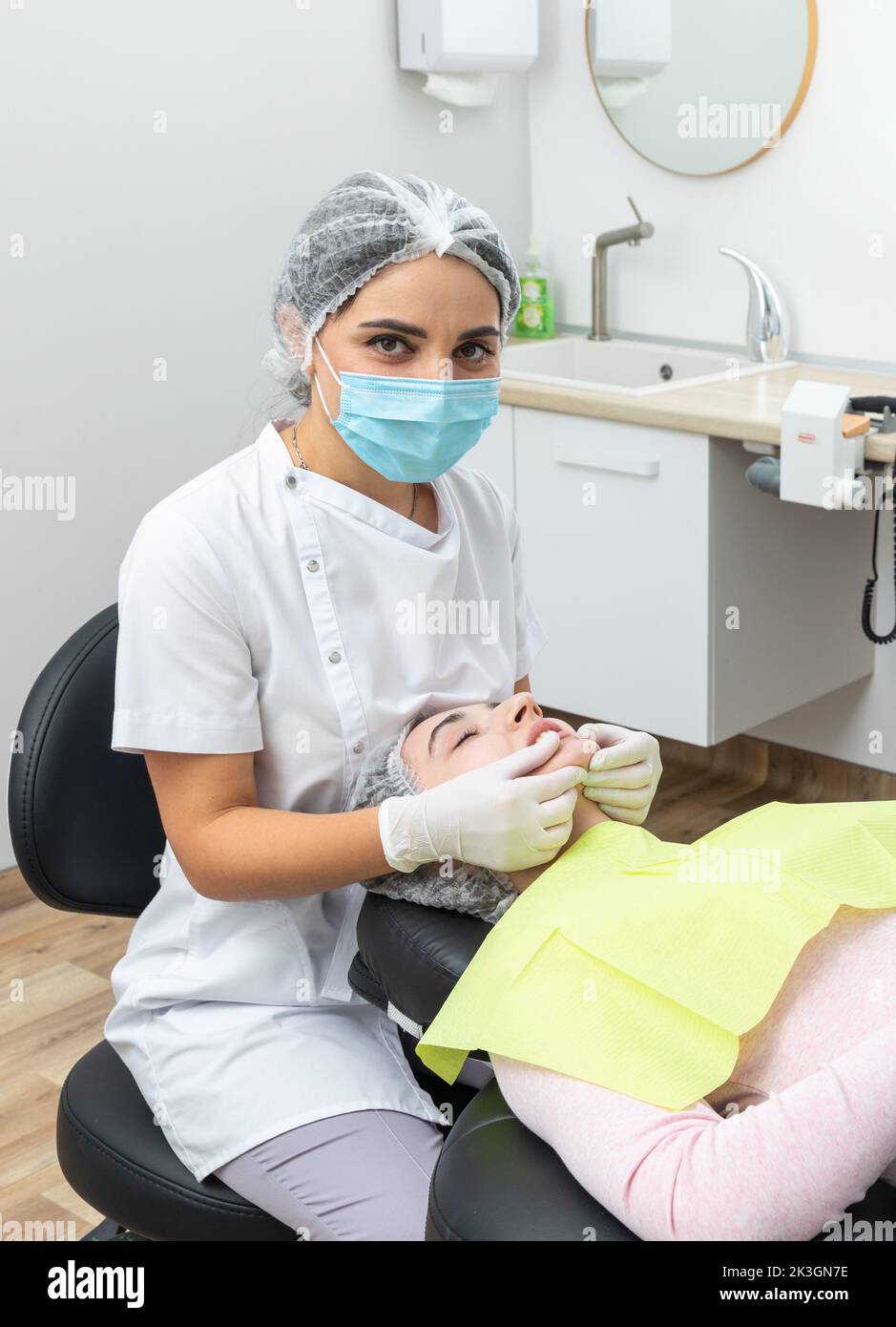 Dentist looks at a jaw of female patient checking the bite Stock Photo