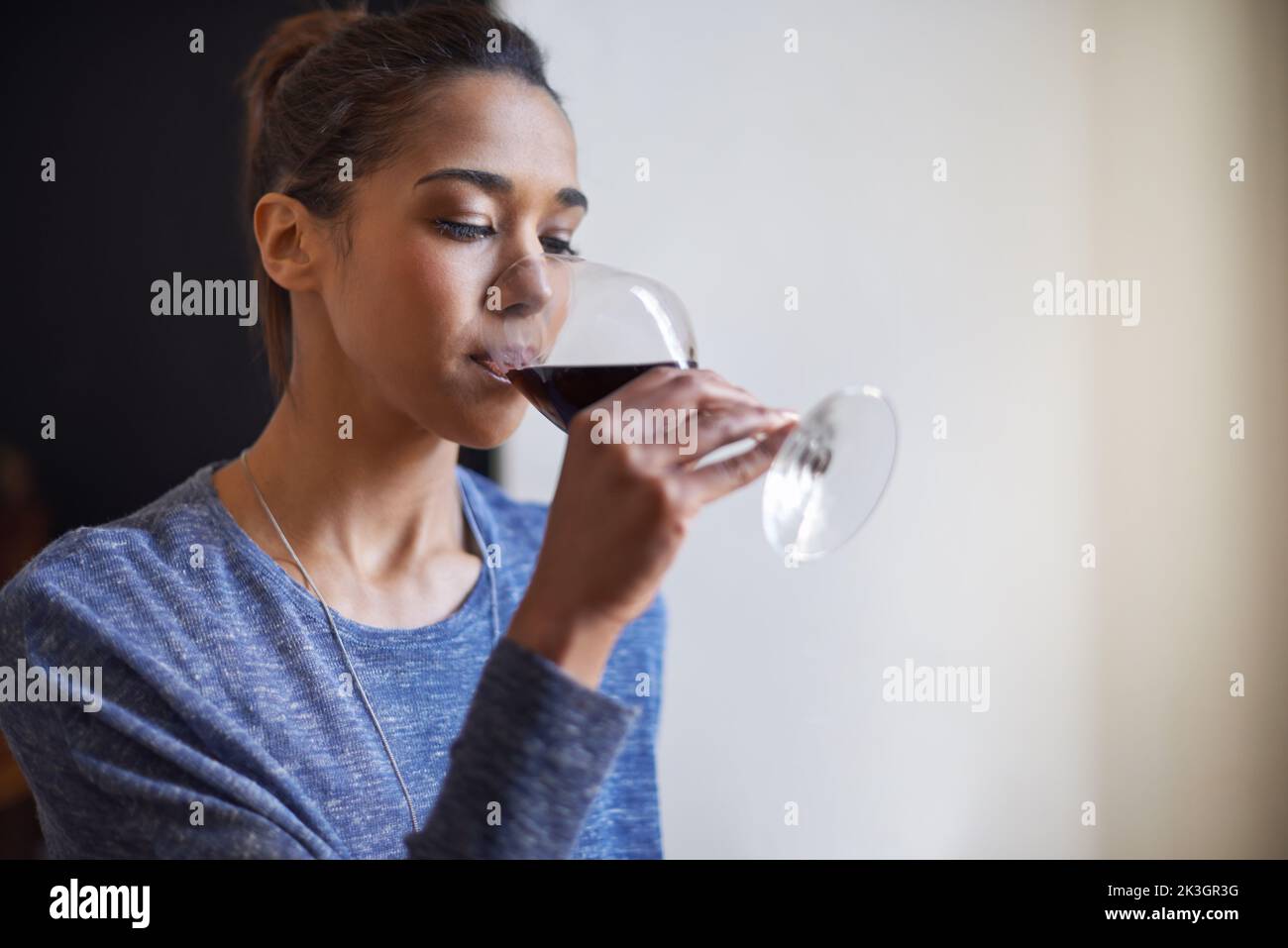 Time for a glass of wine. A young woman drinking some red wine. Stock Photo