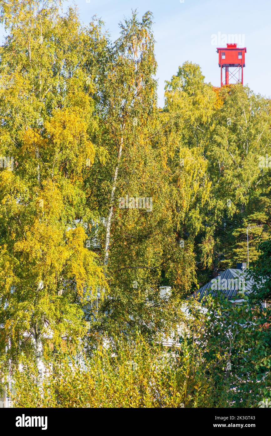 Autumnal foliage on Pispala ridge with red Pispala Shot Tower (Haulitorni) in the background in Tampere Finland Stock Photo