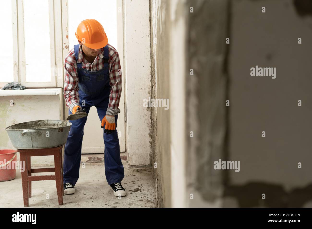 Man builder plasterer using trowel to plastering cement wall in home. building construction work and repair concept Stock Photo