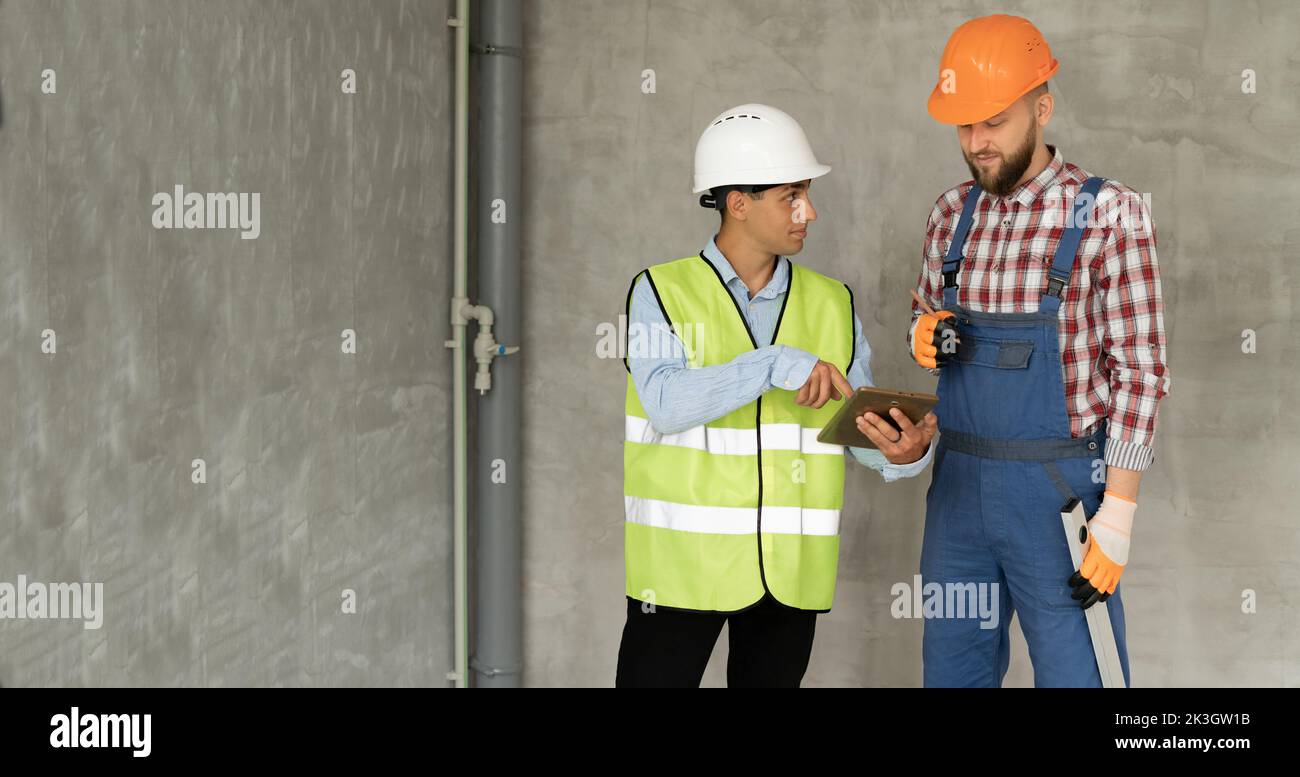 Muslim builder and civil engineer with tablet pc computer indoors. Making a decision on the performance of repair work. building, renovation, technolo Stock Photo