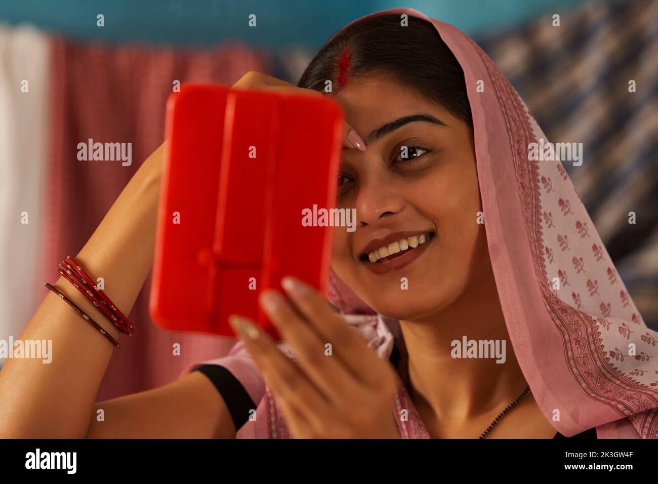 Portrait of Bihar woman applying bindi on forehead Stock Photo