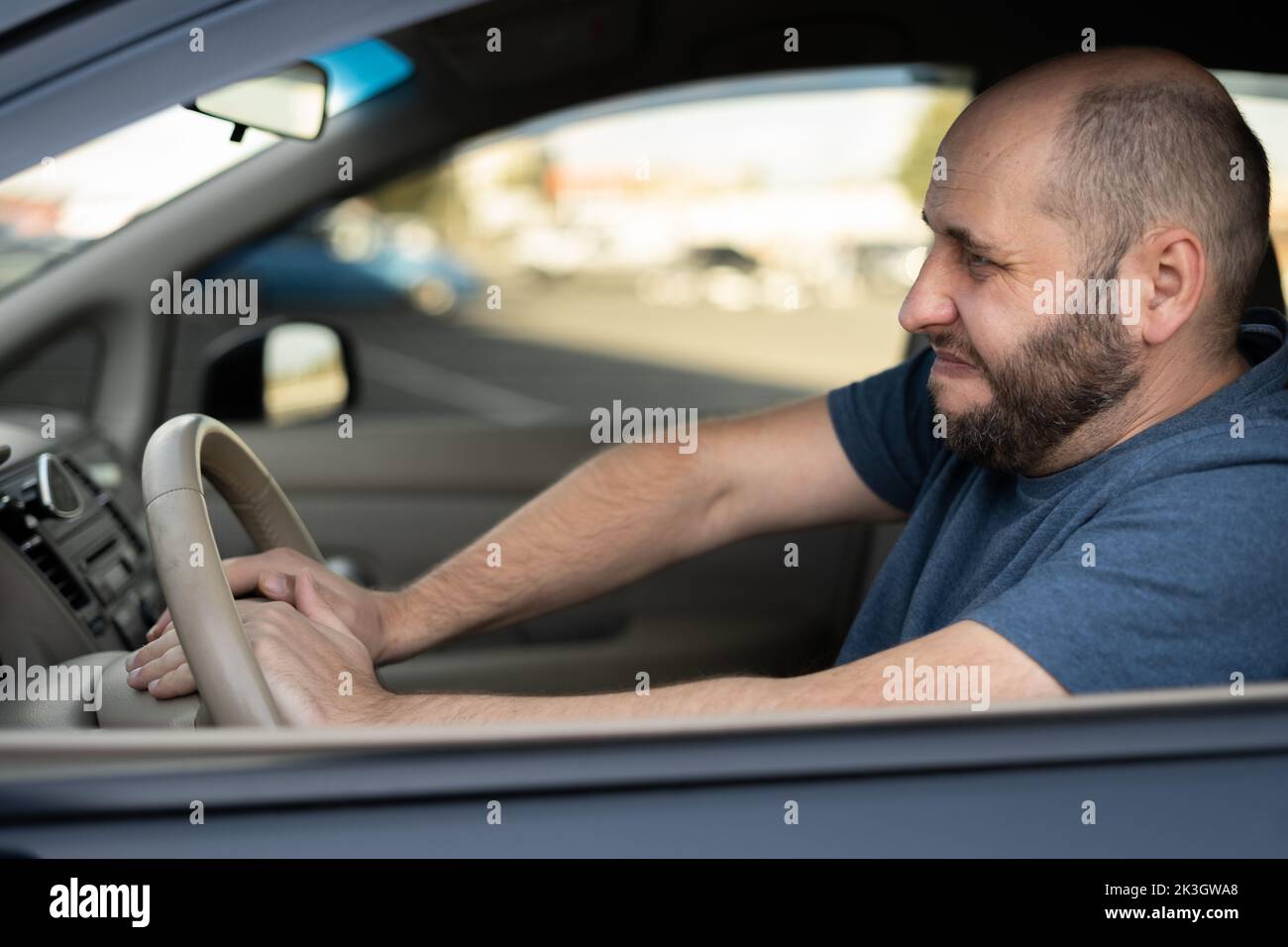 Middle-aged man driving his car, pressing horn while in a traffic jam. Car Driver Honking, close up Stock Photo