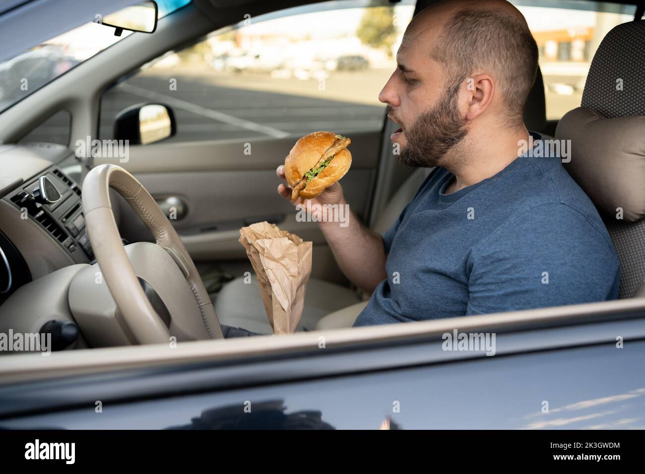 man eat hamburger in car, traffic jam, food take away Stock Photo Alamy