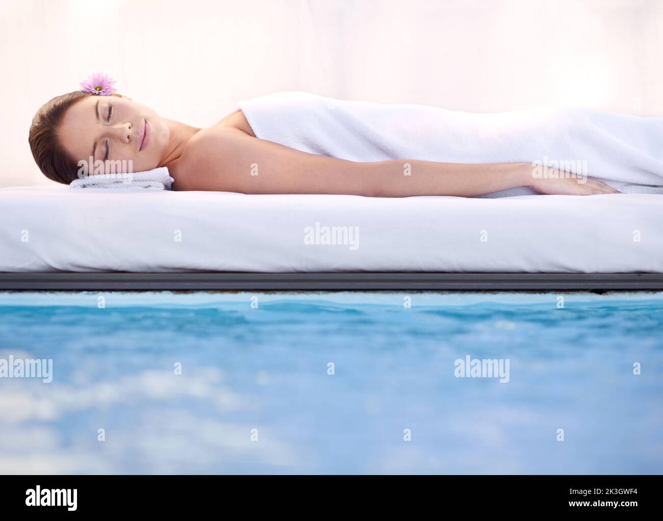 Life doesnt get better than this. a young woman relaxing by a pool at a spa. Stock Photo