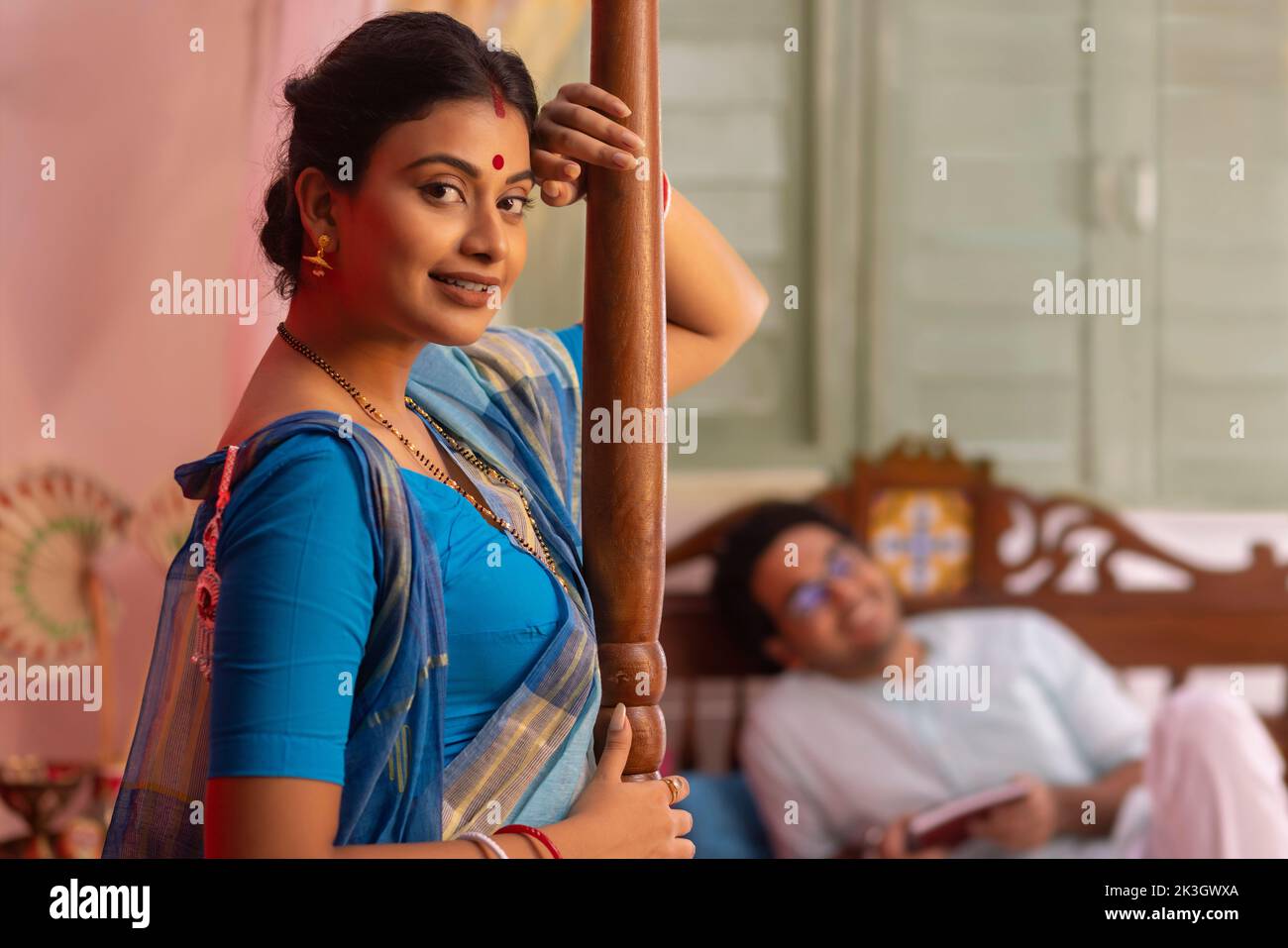 Portrait of Bengali woman standing and husband lying away on bed Stock Photo Alamy