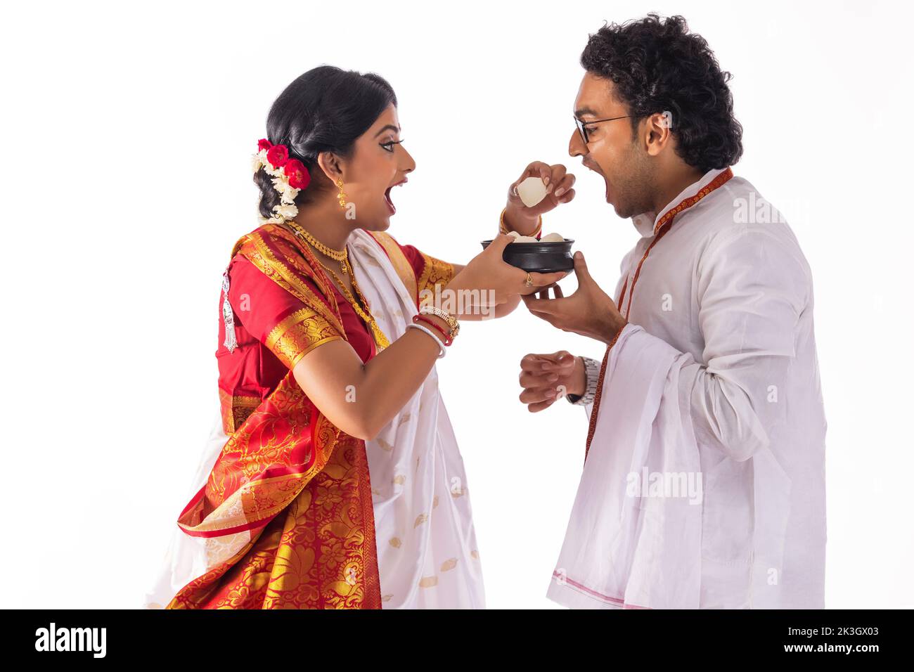Portrait of Bengali woman feeding rosogolla to her husband Stock Photo
