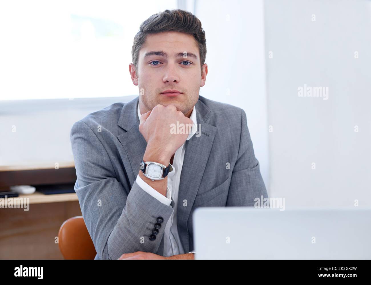Arrogant boss. A serious young businessman looking thoughtful at his desk. Stock Photo