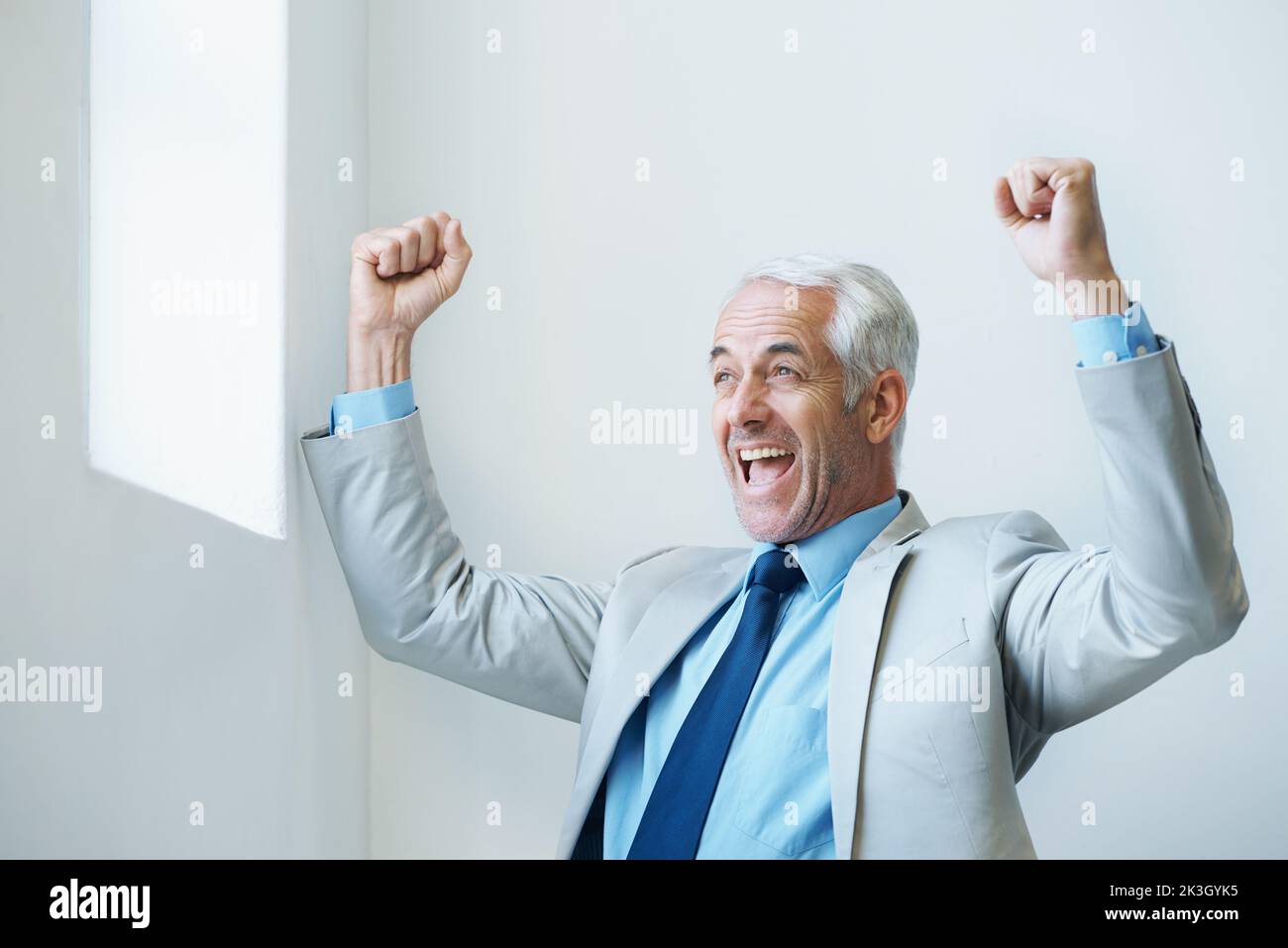 Time for business. a mature businessman with his arms raised in victory ...