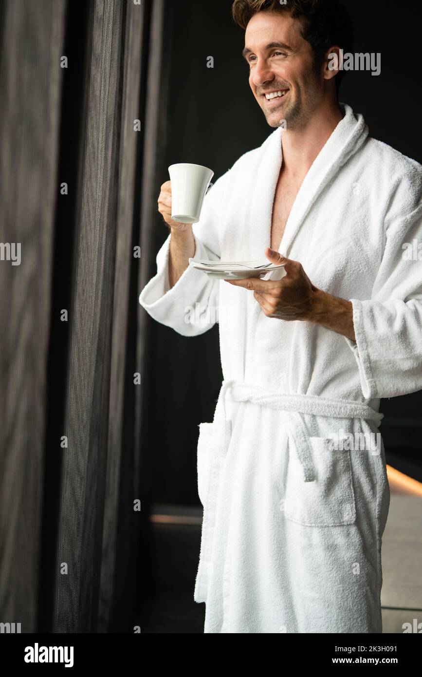 Young man drinking coffee in the morning at hotel, spa Stock Photo