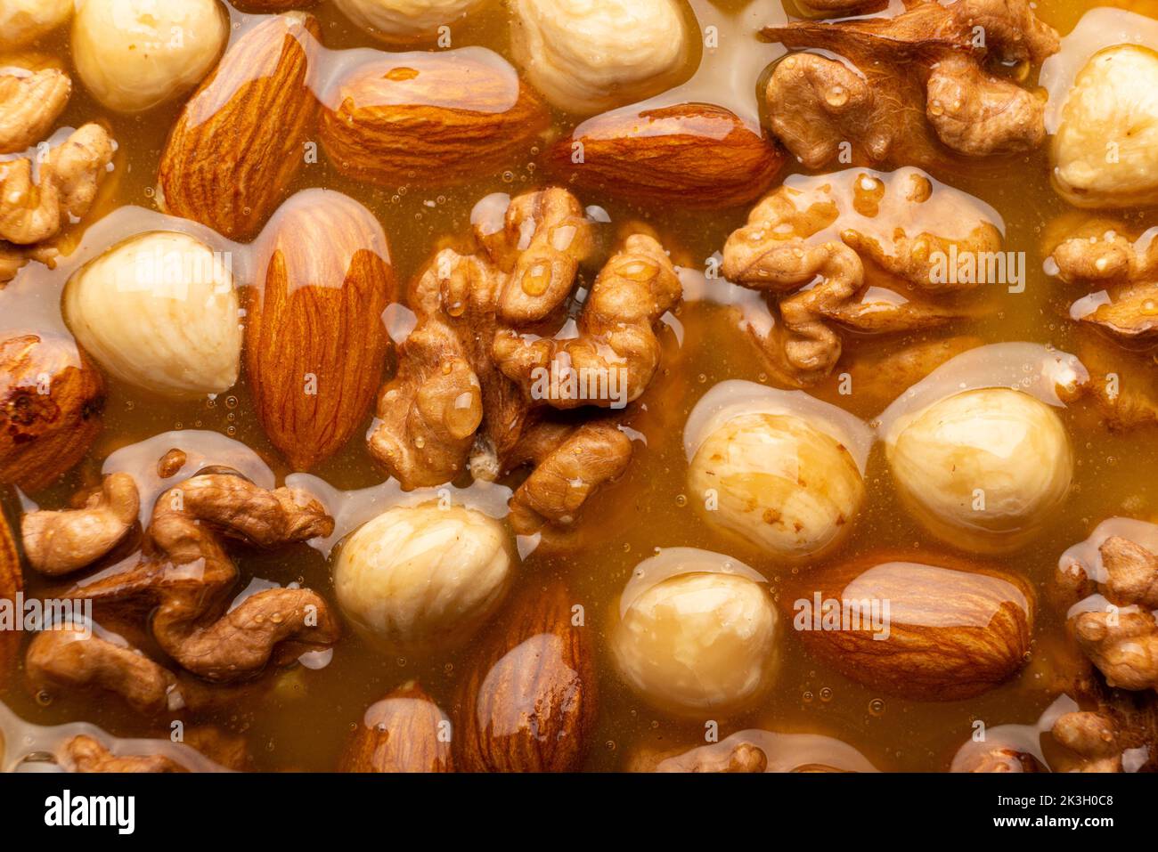 Honeyed assorted nuts organic food background flat view Stock Photo