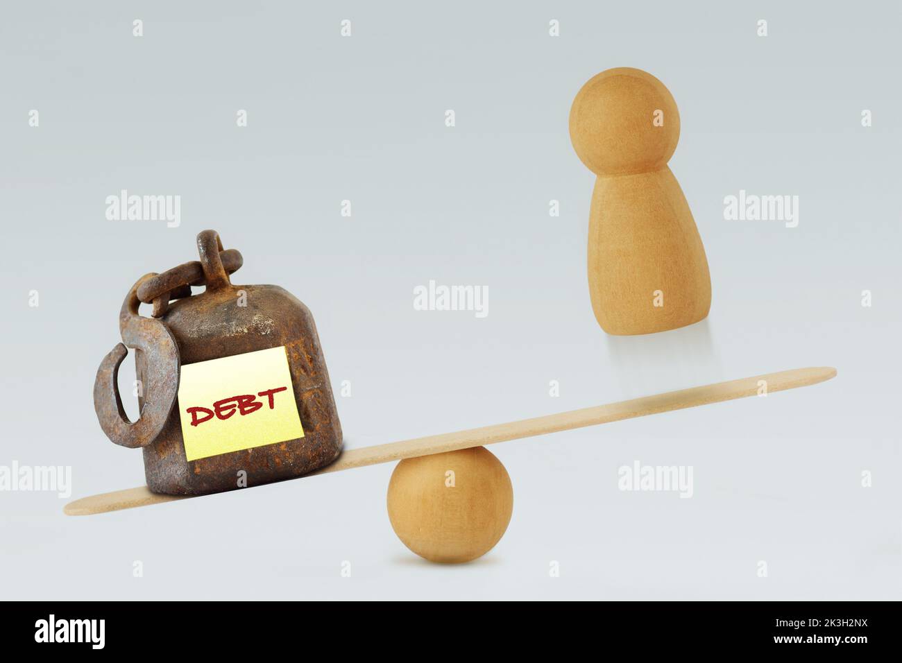 Weight with the word Debt and pawn on balance scale - Concept of debt and financial problems Stock Photo