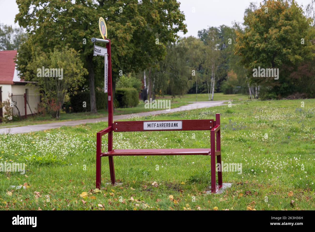 A bench with a sign with the German inscription rideshare bank and directional signs with the German inscriptions Opencast mining lake and Old town Stock Photo