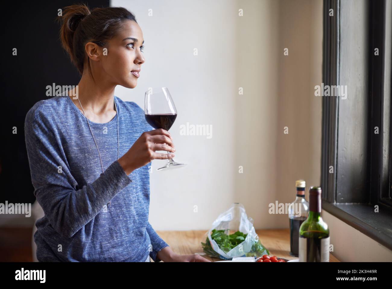 Time for a glass of wine. A young woman drinking some red wine. Stock Photo