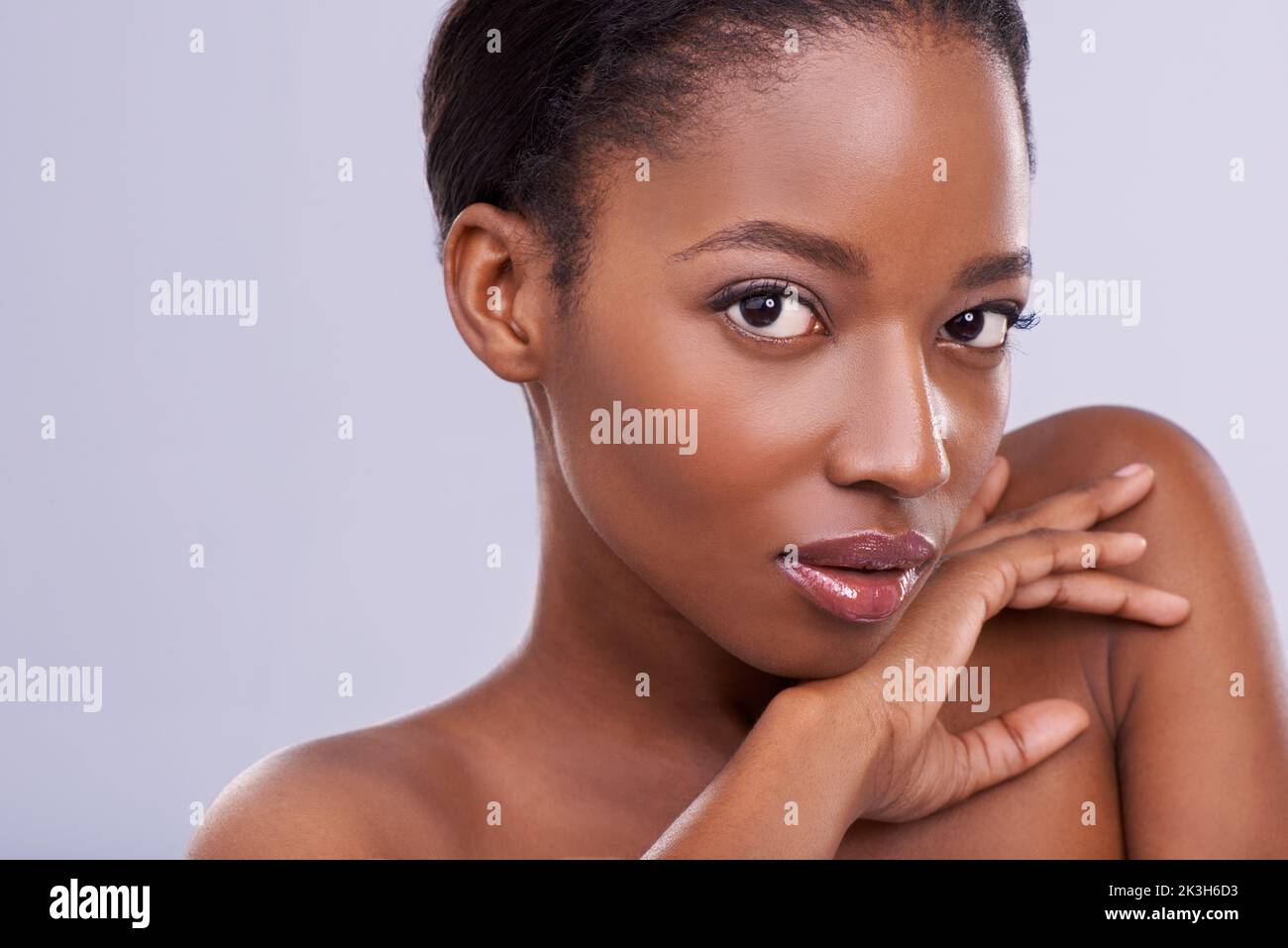 Serious beauty. an attractive young woman touching her skin Stock Photo ...