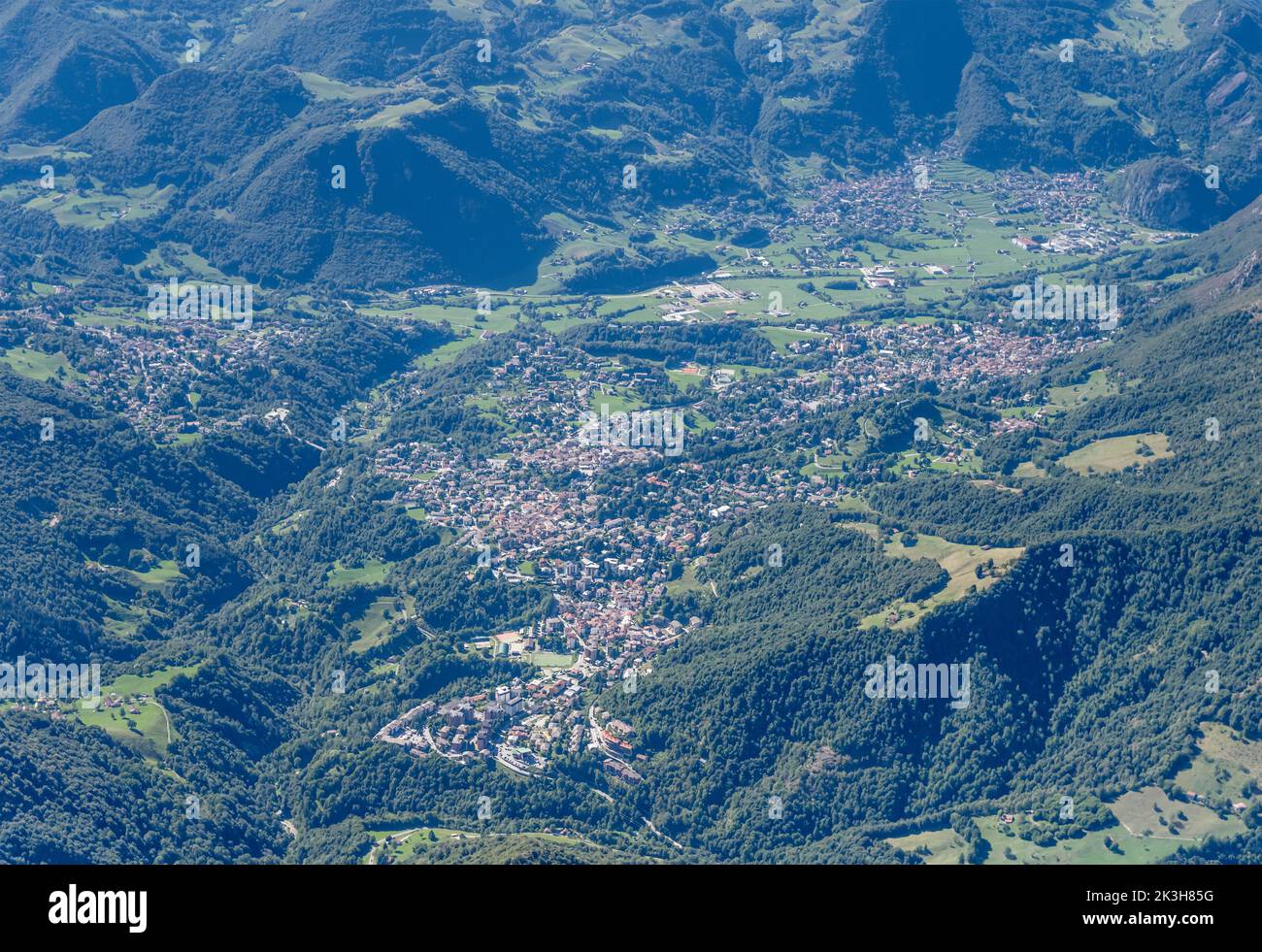 aerial shot, from a glider, of Barzio and Moggio mountain villages in Valsassina valley, shot from east in bright summer light,  Alps, Italy Stock Photo