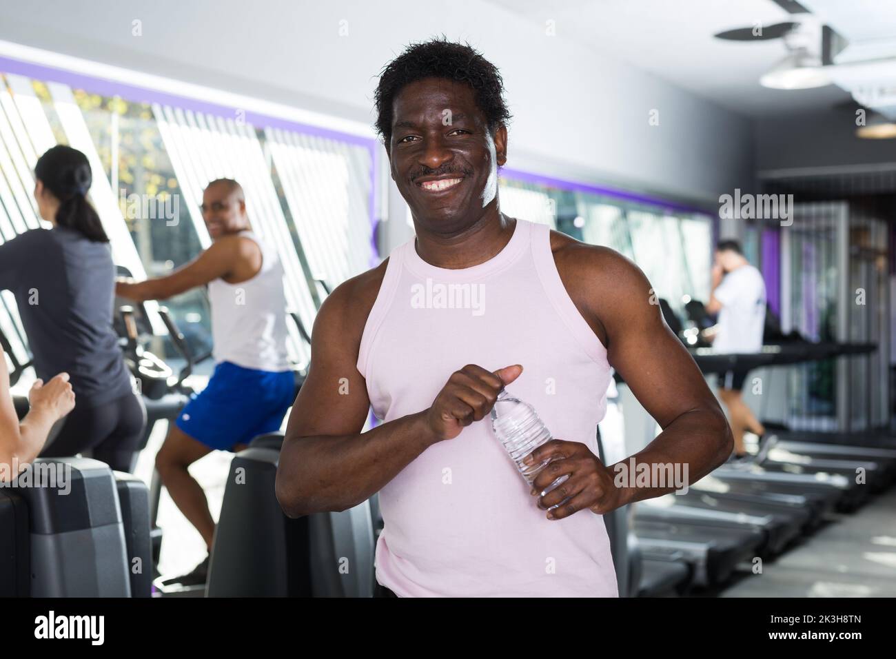 Man with bottle of water in sports club Stock Photo - Alamy