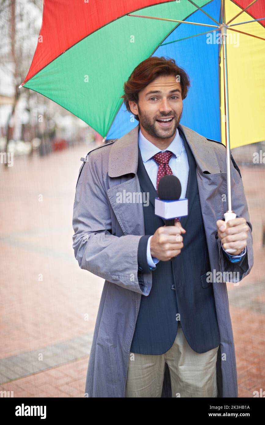 And it looks like rain today folks. A smiling weatherman reporting from an urban area. Stock Photo