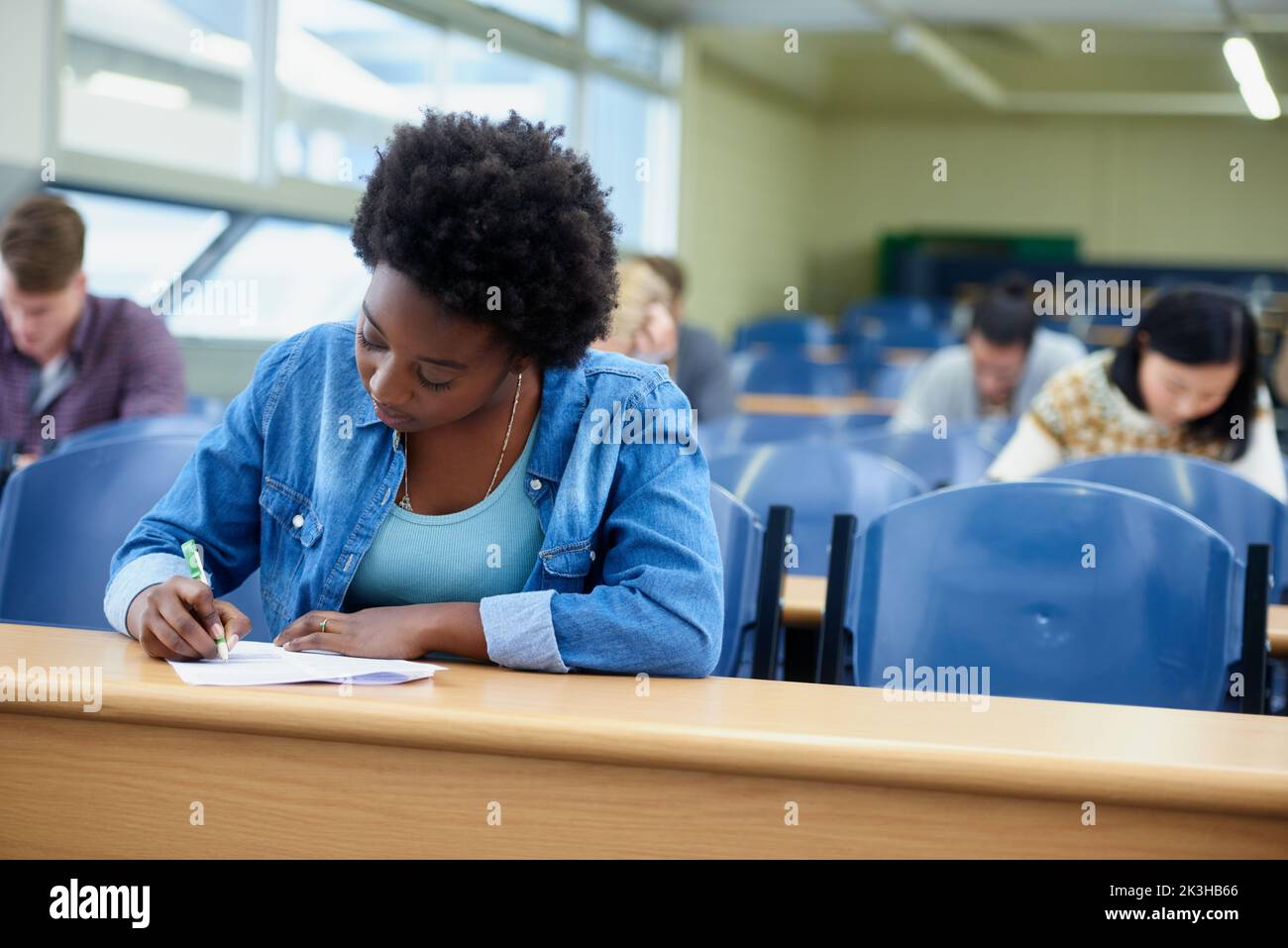 Glad I crammed last night...an attractive college student studying in a lecture hall. Stock Photo