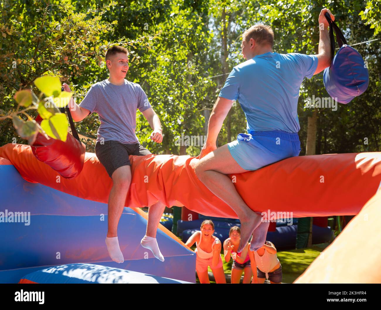 Men having pillow fight between each other in outdoor amusement park ...