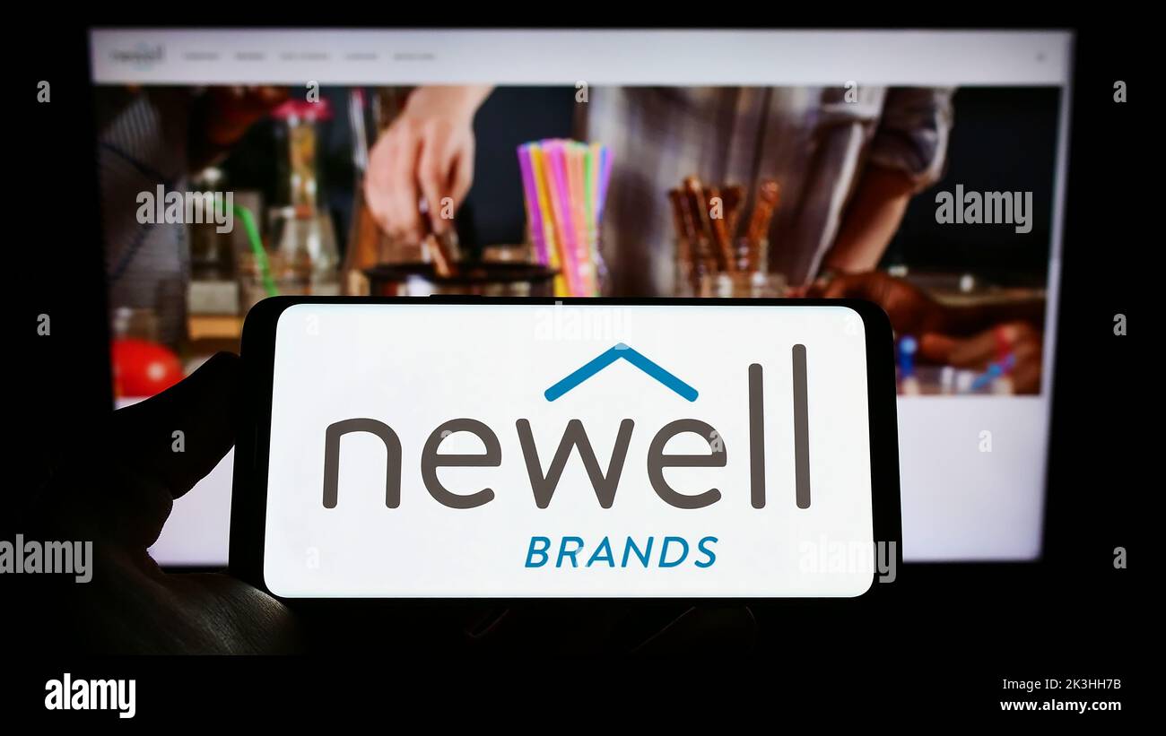 Person holding smartphone with logo of US consumer goods company Newell Brands Inc. on screen in front of website. Focus on phone display. Stock Photo