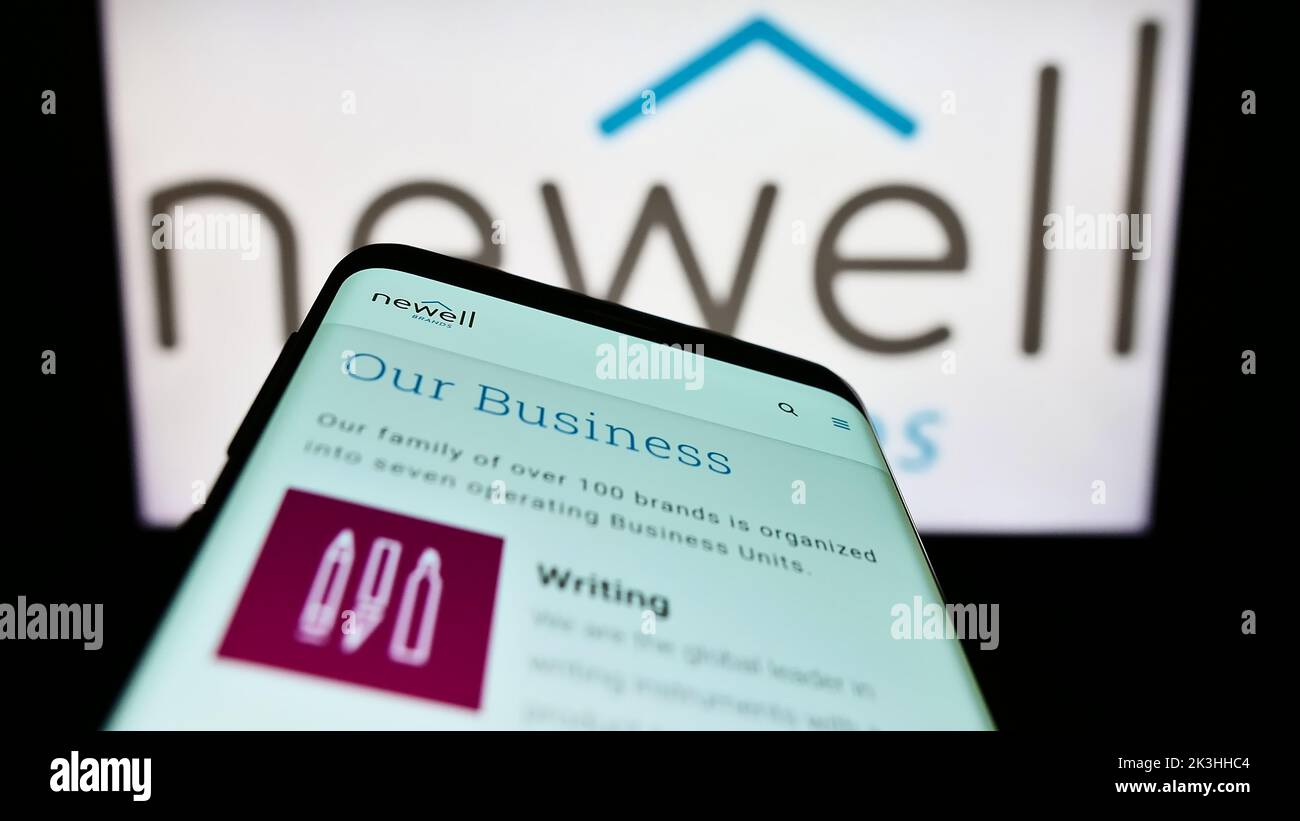 Mobile phone with website of US consumer goods company Newell Brands Inc. on screen in front of business logo. Focus on top-left of phone display. Stock Photo