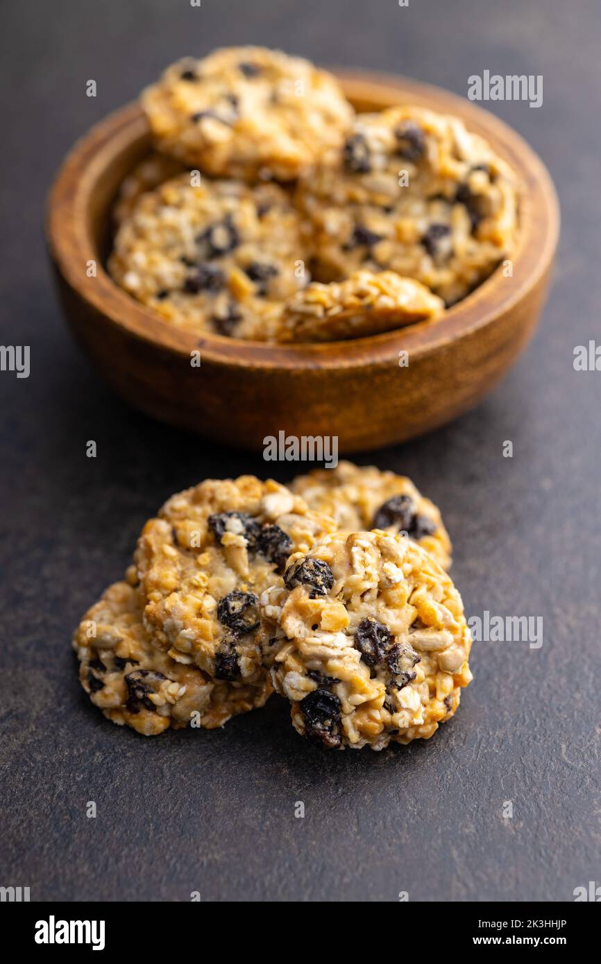 Wholegrain oat cookies. Cookies with oatmeal and raisins on the dark table. Stock Photo