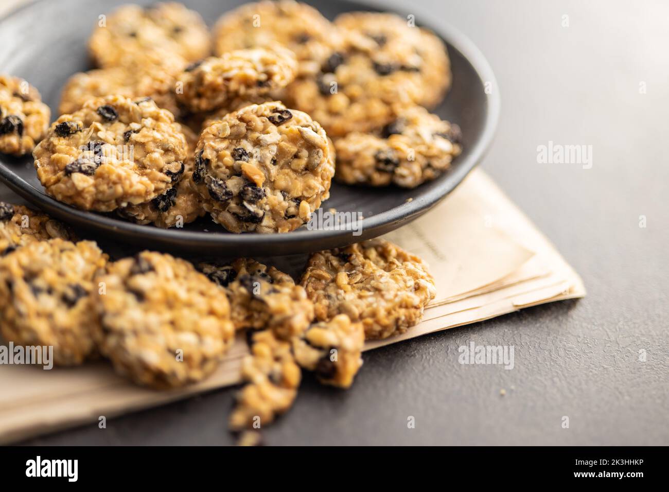 Wholegrain oat cookies. Cookies with oatmeal and raisins on the newspapers. Stock Photo
