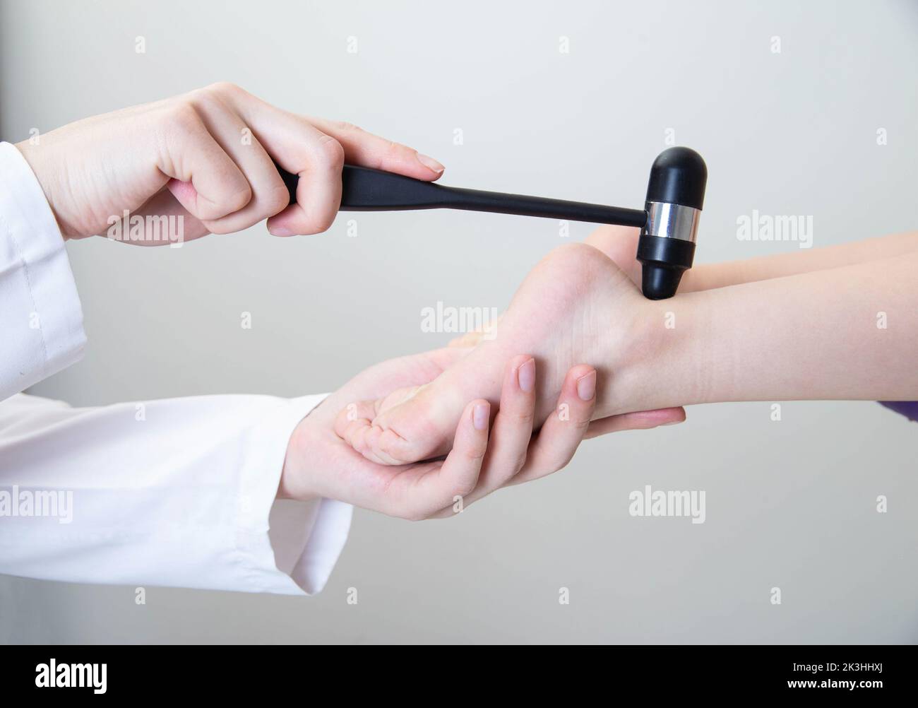 Doctor neuropathologist checks the child's Achilles reflex on the leg