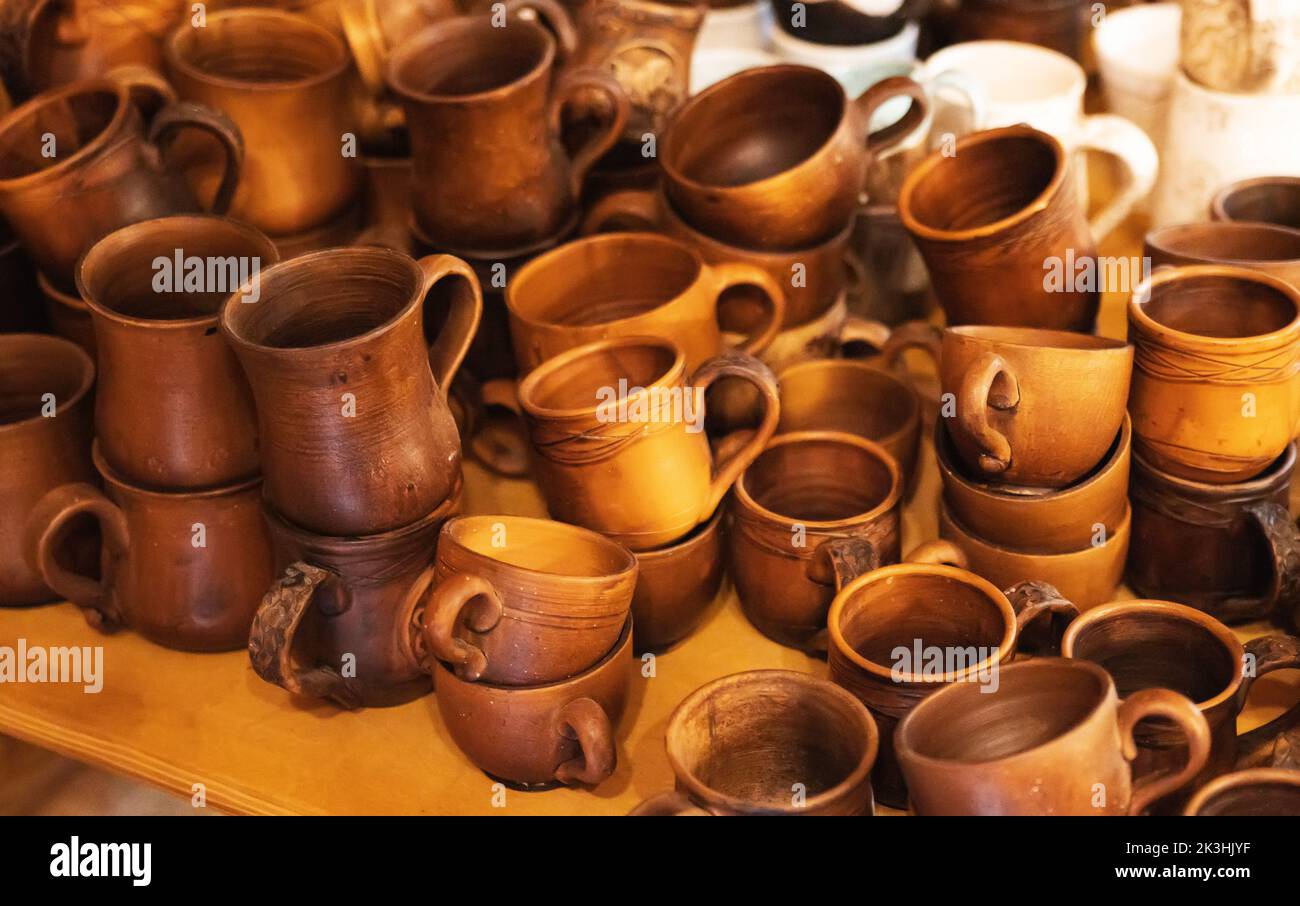 A collection of earthenware, many mugs and jugs on the table