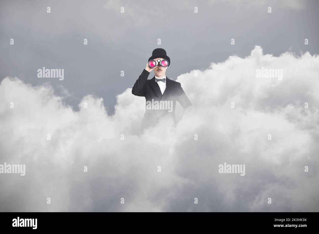 surreal businessman with spyglass comes out of a cloud to scan the future Stock Photo