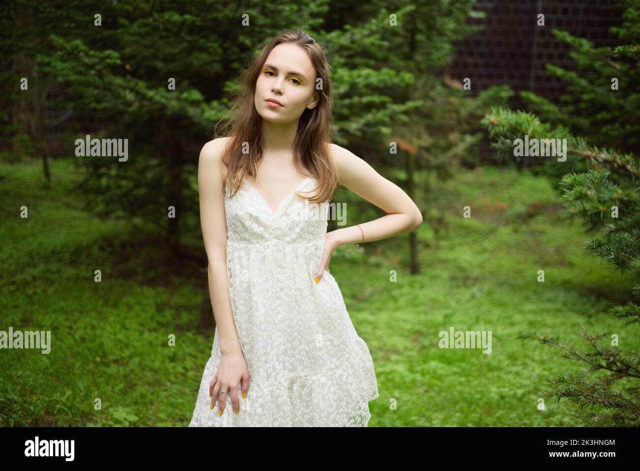City portrait of beautiful young woman in white dress. Stock Photo
