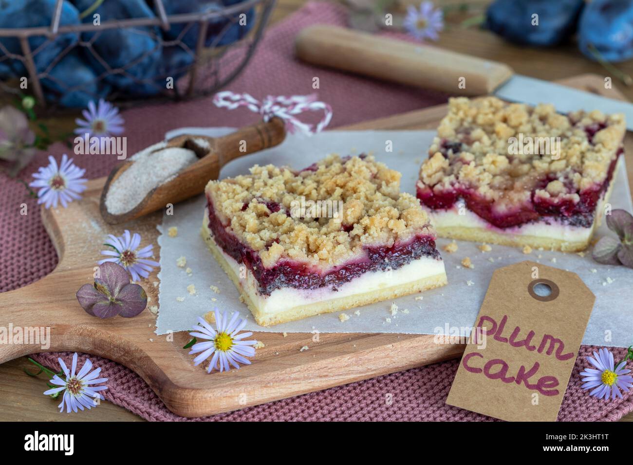 pieces of plum poppy seed cheesecake with cinnamon crumble on wooden board Stock Photo