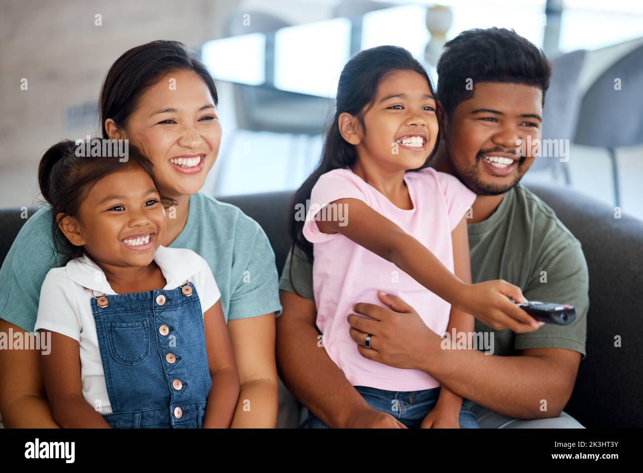 Happy family, watching tv and television on sofa in living room, internet streaming video or funny comedy movie. Relax, love and comfort of mom, dad Stock Photo