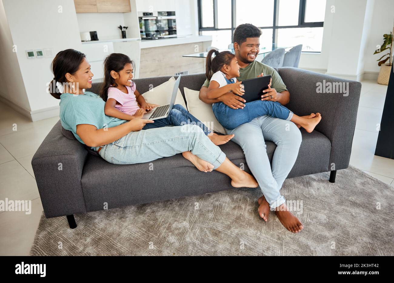 Family, children and technology with a girl, sister and parents streaming an online subscription service in a living room. Tablet, laptop and internet Stock Photo