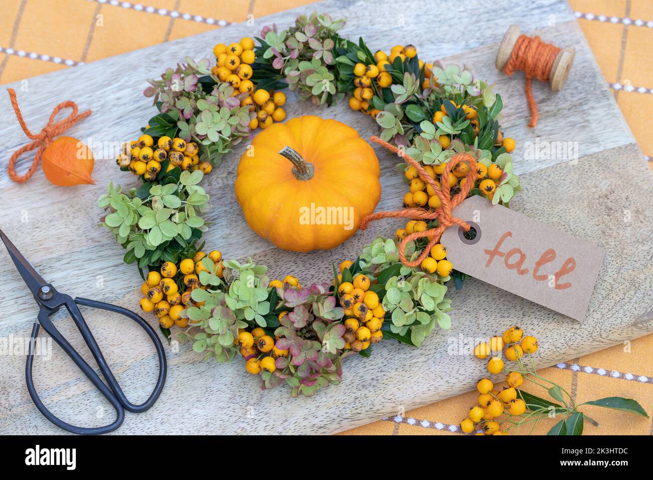 wreath of firethorn berries, hydrangea flowers and box tree branches as autumn floral decoration Stock Photo